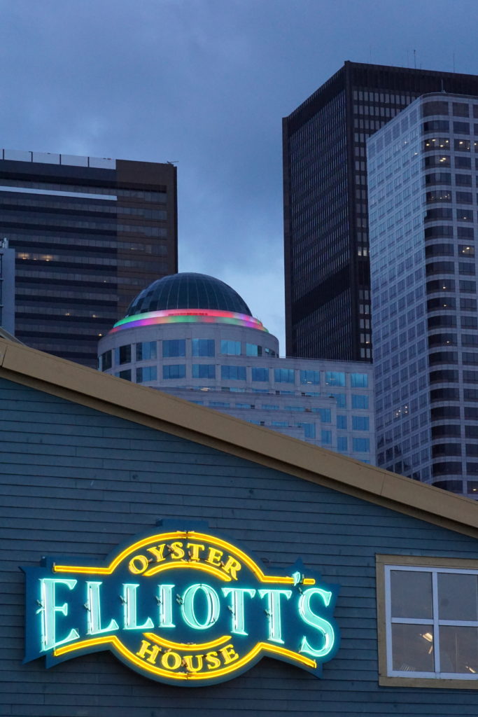 Seattle skyscrapers behind Elliot's Oyster House Neon sign at dusk